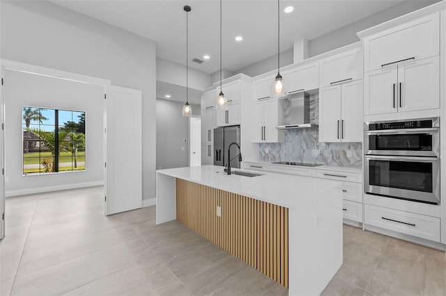 2716 SW 13th Ave, Cape Coral, FL 33914 - kitchen featuring an island with sink, a sink, appliances with stainless steel finishes, wall chimney exhaust hood, and tasteful backsplash