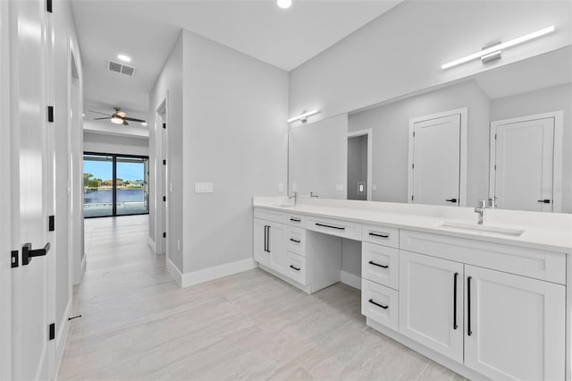 2716 SW 13th Ave, Cape Coral, FL 33914 - bathroom featuring a ceiling fan, baseboards, visible vents, double vanity, and a sink