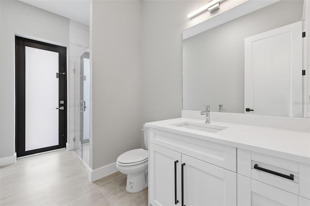 2716 SW 13th Ave, Cape Coral, FL 33914 - bathroom featuring baseboards, toilet, a stall shower, and vanity