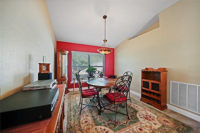 dining area with visible vents, baseboards, and vaulted ceiling