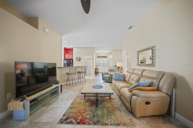 living room with visible vents, baseboards, a ceiling fan, and vaulted ceiling