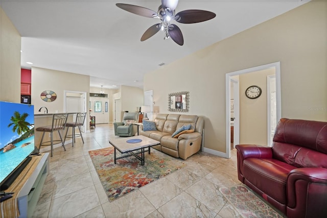 living area with visible vents, baseboards, and ceiling fan