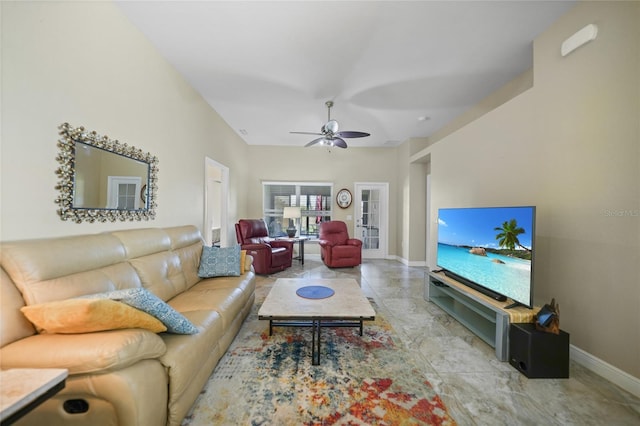 living area featuring baseboards and a ceiling fan