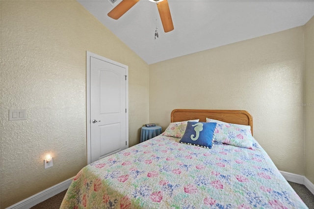 carpeted bedroom with a textured wall, baseboards, a ceiling fan, and vaulted ceiling