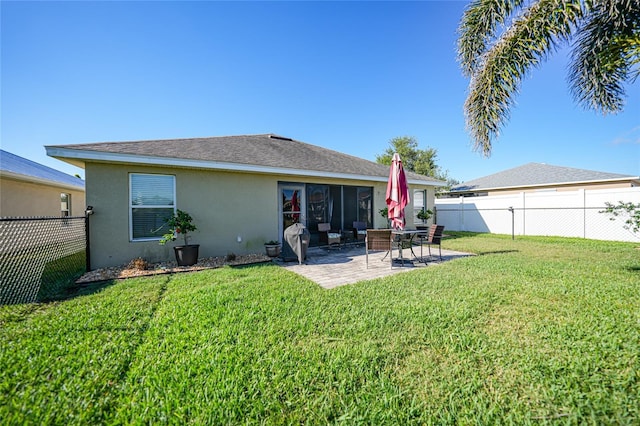 rear view of property with a patio area, a fenced backyard, stucco siding, and a yard