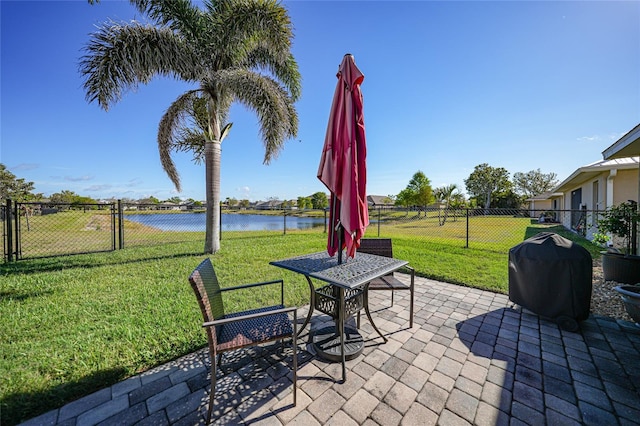 view of patio with grilling area, a water view, fence, and a gate
