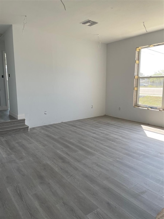 unfurnished room with visible vents and wood finished floors