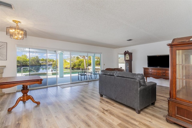535 Ramblewood St, Port Charlotte, FL 33953 - living area with light wood-style flooring, a textured ceiling, a chandelier, and visible vents