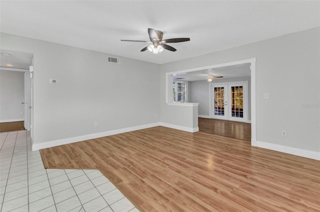 unfurnished living room featuring light wood-style flooring, visible vents, ceiling fan, and french doors