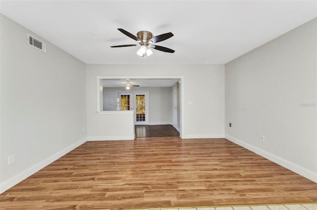 empty room with visible vents, baseboards, light wood-style floors, and ceiling fan