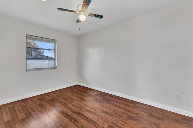 empty room with baseboards, wood finished floors, and a ceiling fan
