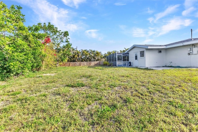 view of yard featuring a lanai and fence