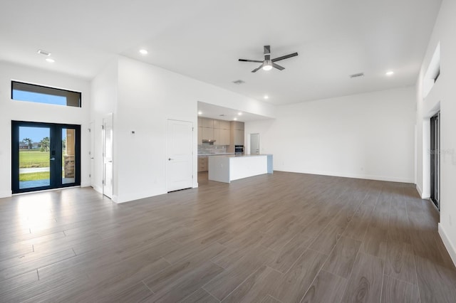 unfurnished living room with visible vents, baseboards, recessed lighting, a ceiling fan, and dark wood-style flooring