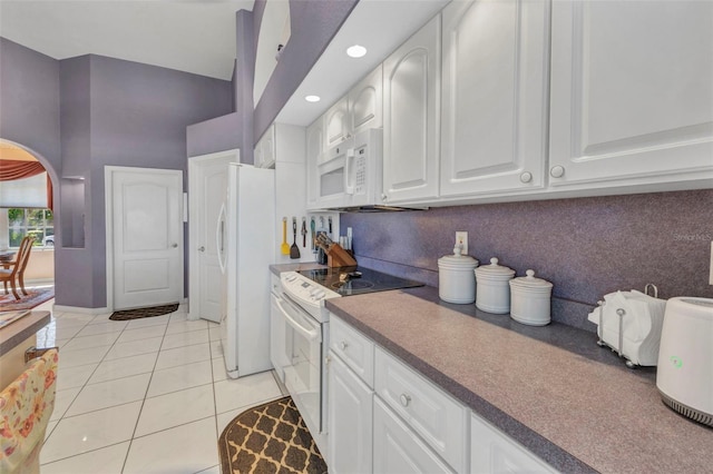412 Panarea Dr, Punta Gorda, FL 33950 - kitchen with light tile patterned floors, white appliances, arched walkways, and white cabinetry