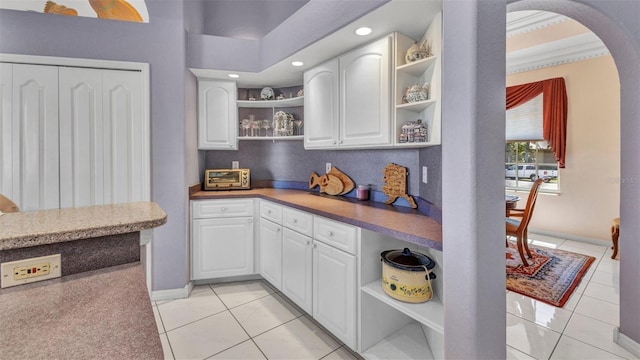 412 Panarea Dr, Punta Gorda, FL 33950 - kitchen with open shelves, light tile patterned flooring, recessed lighting, arched walkways, and white cabinets
