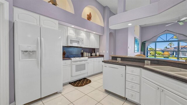 412 Panarea Dr, Punta Gorda, FL 33950 - kitchen with a ceiling fan, dark countertops, white cabinetry, white appliances, and light tile patterned floors