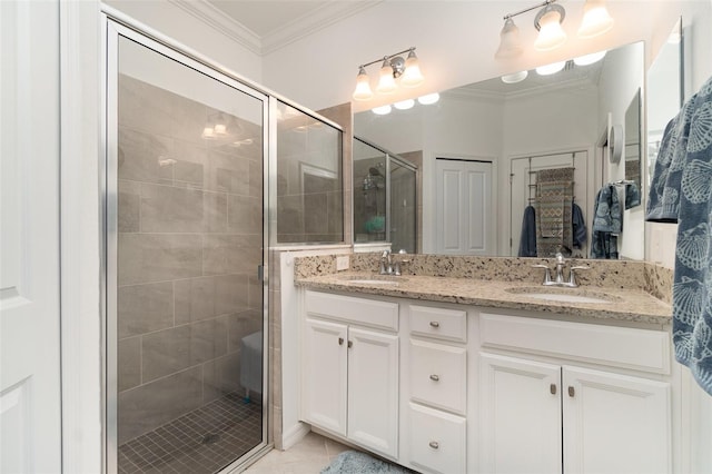 bathroom with a sink, crown molding, and a stall shower