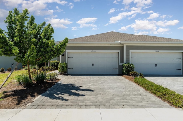 exterior space with stucco siding, an attached garage, and decorative driveway
