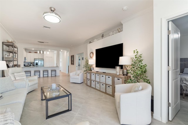 living room featuring visible vents, ornamental molding, and light tile patterned floors
