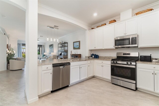 kitchen with crown molding, a peninsula, appliances with stainless steel finishes, arched walkways, and open floor plan