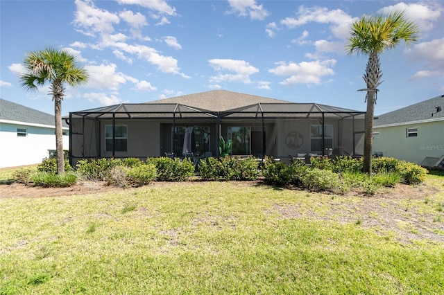 rear view of property featuring a lawn and glass enclosure