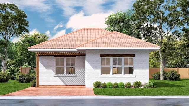 view of front of home featuring brick siding, a tile roof, a front lawn, and fence