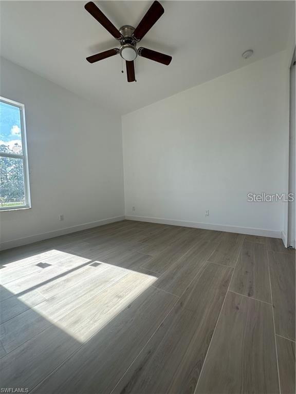 8136 Sweden Blvd, Punta Gorda, FL 33982 - empty room with baseboards, wood finished floors, and a ceiling fan