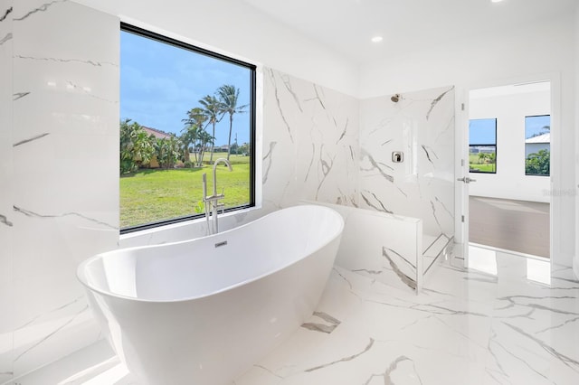 24259 Peppercorn Rd, Punta Gorda, FL 33955 - bathroom with recessed lighting, a freestanding tub, marble finish floor, and stone wall