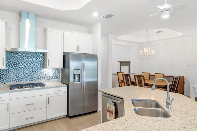 15931 Sugar Hill Dr, Punta Gorda, FL 33982 - kitchen with light wood-type flooring, visible vents, wall chimney exhaust hood, stainless steel appliances, and a sink