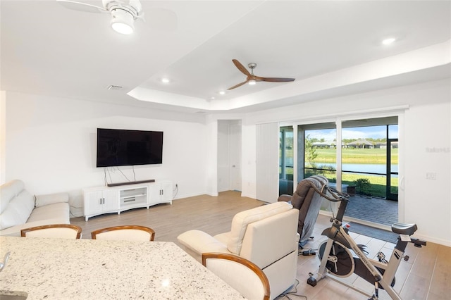15931 Sugar Hill Dr, Punta Gorda, FL 33982 - living area featuring ceiling fan, light wood-style flooring, a tray ceiling, recessed lighting, and baseboards