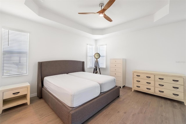 15931 Sugar Hill Dr, Punta Gorda, FL 33982 - bedroom featuring a tray ceiling, baseboards, and light wood-style flooring