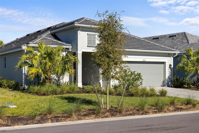 15931 Sugar Hill Dr, Punta Gorda, FL 33982 - view of front of property featuring a tiled roof, concrete driveway, stucco siding, and a garage