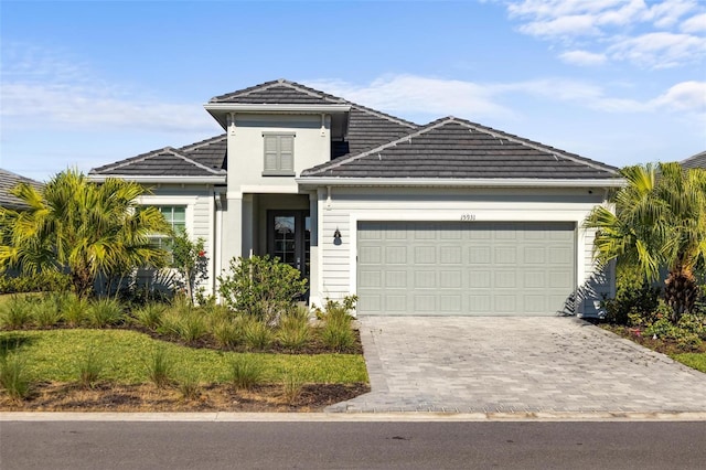 15931 Sugar Hill Dr, Punta Gorda, FL 33982 - traditional-style house featuring a garage, stucco siding, a tile roof, and decorative driveway