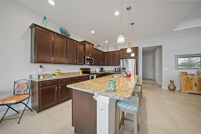 kitchen with a sink, appliances with stainless steel finishes, light stone counters, and recessed lighting