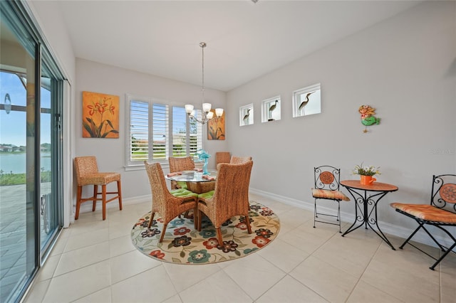 dining area with baseboards, a chandelier, and light tile patterned floors