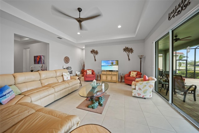 living area featuring a tray ceiling, ceiling fan, recessed lighting, and light tile patterned floors