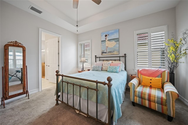 bedroom with carpet flooring, a raised ceiling, baseboards, and visible vents