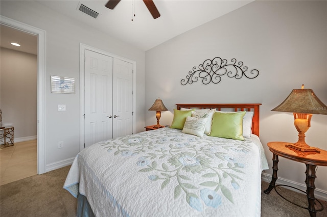 bedroom with a closet, carpet flooring, visible vents, baseboards, and a ceiling fan