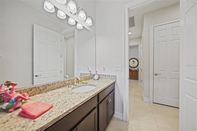 bathroom featuring tile patterned flooring, vanity, baseboards, and visible vents