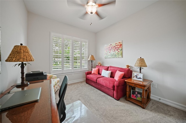 carpeted office space featuring a ceiling fan and baseboards
