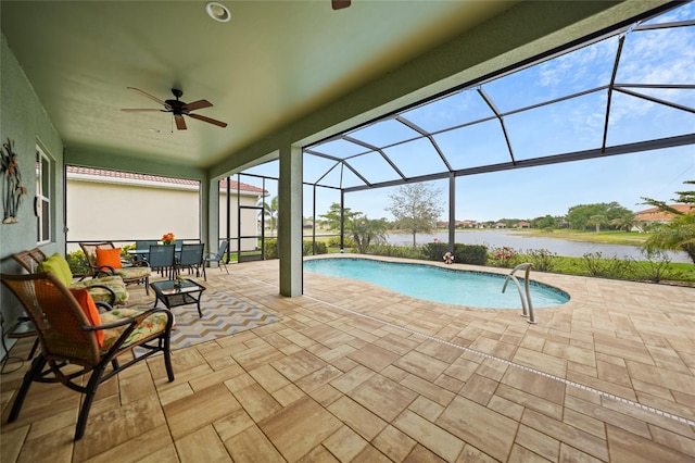 outdoor pool featuring a water view, glass enclosure, ceiling fan, and a patio area
