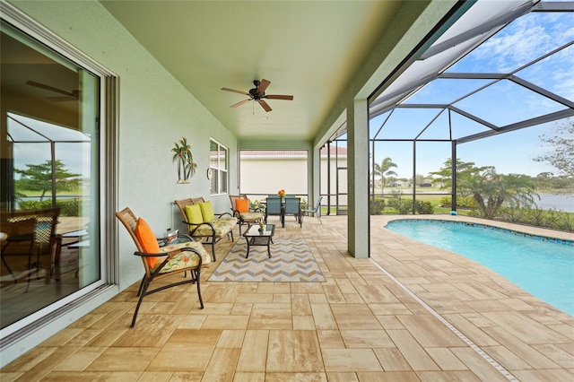 pool with a lanai, a patio area, and a ceiling fan