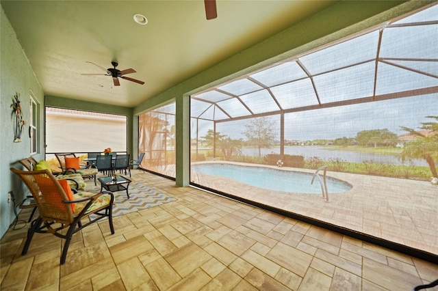 unfurnished sunroom featuring a water view and a ceiling fan