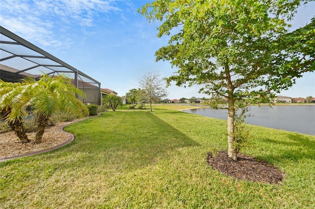view of yard featuring glass enclosure and a water view