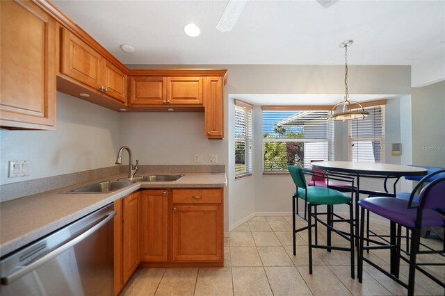 3753 Aba Ln, North Port, FL 34287 - kitchen featuring stainless steel dishwasher, pendant lighting, light countertops, brown cabinetry, and light tile patterned flooring