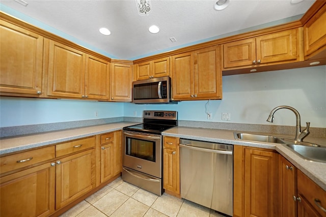 3753 Aba Ln, North Port, FL 34287 - kitchen with appliances with stainless steel finishes, brown cabinets, light tile patterned floors, light countertops, and recessed lighting
