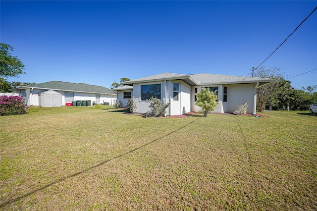 3753 Aba Ln, North Port, FL 34287 - rear view of house featuring a storage shed, a yard, and stucco siding