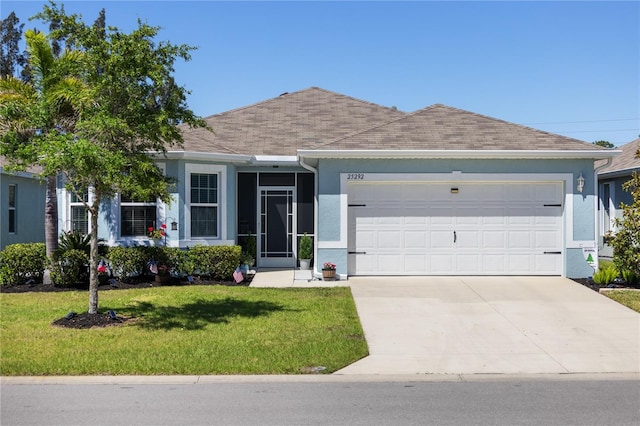 ranch-style home with a garage, a front yard, driveway, and stucco siding