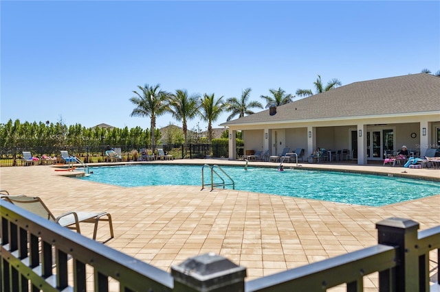 community pool with a patio and fence