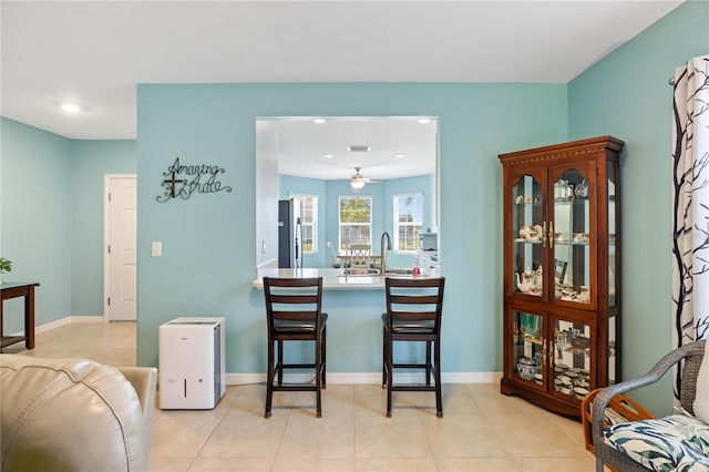 tiled dining area featuring a sink, a ceiling fan, baseboards, and recessed lighting